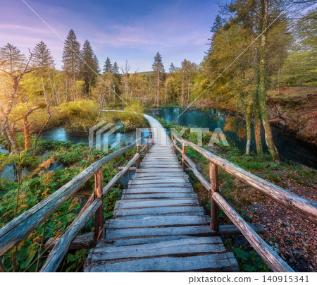 Wooden path in green forest in Plitvice Lakes, Croatia at sunset Wooden path in green forest in Plitvice Lakes, Croatia at sunset 140915341