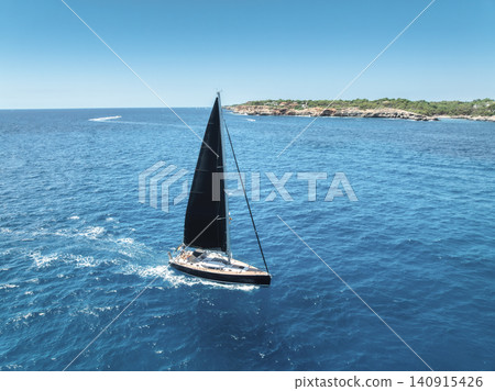 Aerial drone view of sailing yacht with black sails in blue sea Aerial drone view of sailing yacht with black sails in blue sea 140915426