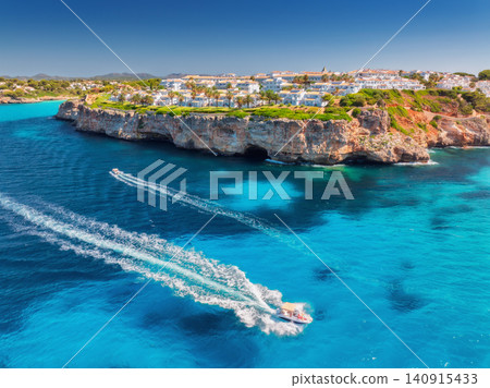 Aerial view of boat and white coastal resort with villas Aerial view of boat and white coastal resort with villas 140915433
