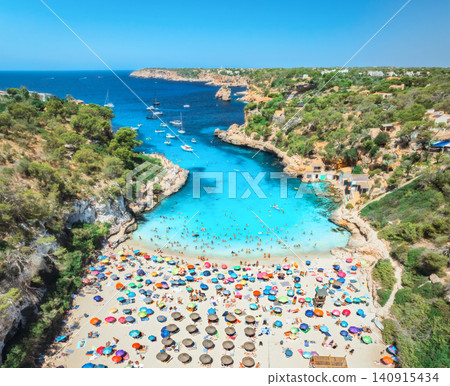 Aerial view of colorful umbrellas on sandy beach, swimming people 140915434