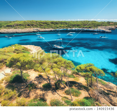 Aerial drone view of yachts in turquoise bay with pine trees Aerial drone view of yachts in turquoise bay with pine trees 140915436