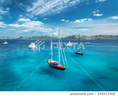 Aerial drone view of yachts and sailboats anchored in blue sea Aerial drone view of yachts and sailboats anchored in blue sea 140915469