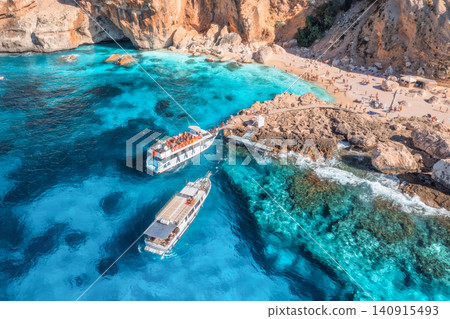 Aerial view of boat and rocky sea coast on sunny summer day Aerial view of boat and rocky sea coast on sunny summer day 140915493