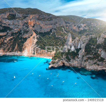 Aerial view of rocks and mountains, blue bay, beach, boats Aerial view of rocks and mountains, blue bay, beach, boats 140915519
