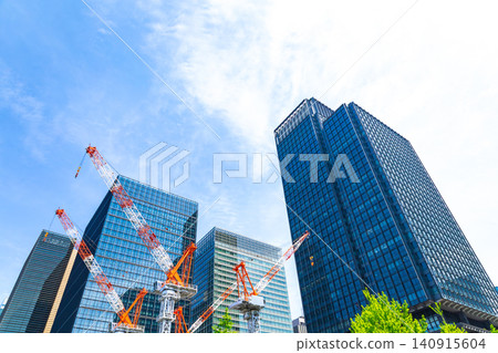 Large cranes and skyscrapers at a construction site 140915604