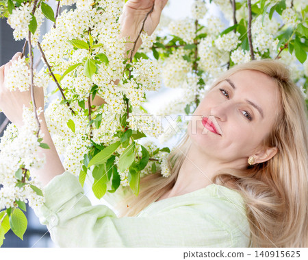 Portrait of a woman with natural beauty at the blooming tree in spring. Portrait of a woman with natural beauty at the blooming tree in spring. 140915625
