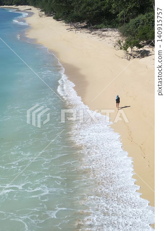Alone woman wandering barefoot along sunriselit beach with peaceful surroundings Alone woman wandering barefoot along sunriselit beach with peaceful surroundings 140915757