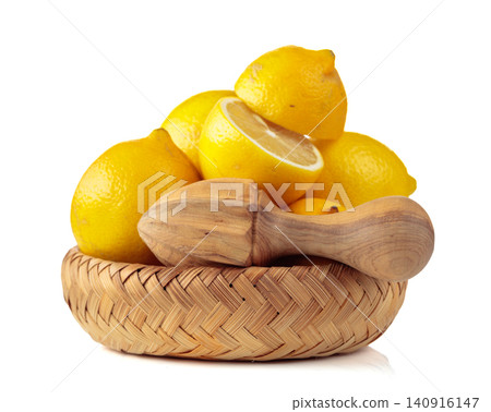 Fresh lemons and wooden juicer isolated on a white background. Fresh lemons and wooden juicer isolated on a white background. 140916147