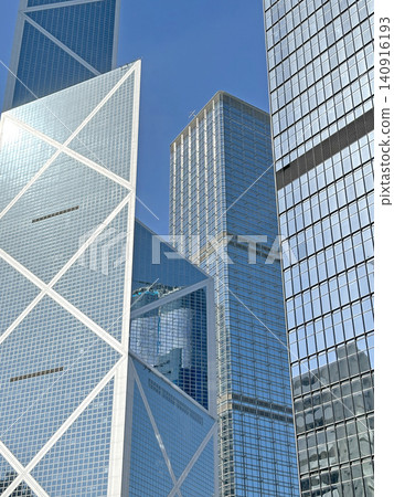 Modern glass skyscrapers reflecting the clear blue sky in a bustling city 140916193