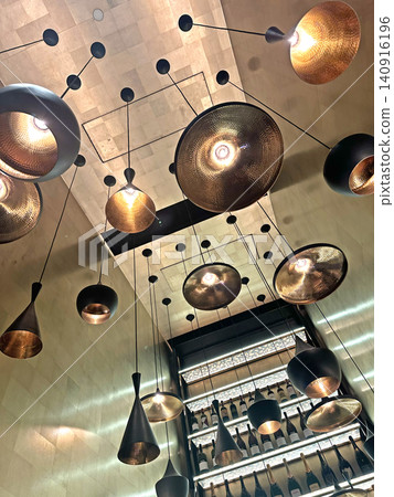 Modern pendant lights with metallic finishes illuminate a stylish interior space Modern pendant lights with metallic finishes illuminate a stylish interior space 140916196