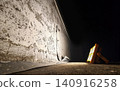 Portable floodlight illuminating damaged concrete wall at night 140916258