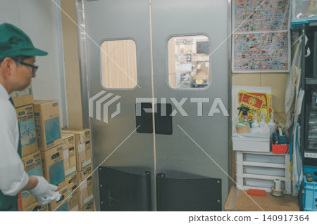 A swing door in front of the staff going from the back room to the sales floor of a supermarket. A swing door in front of the staff going from the back room to the sales floor of a supermarket. 140917364