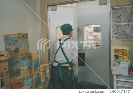 Staff members heading from the supermarket backroom to the sales floor. Staff members heading from the supermarket backroom to the sales floor. 140917367