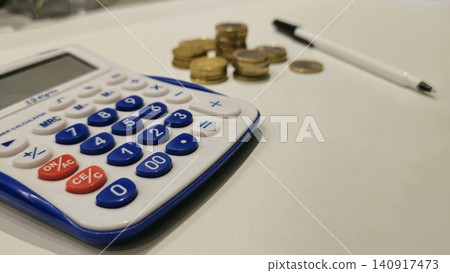 Calculator and Coins on a Desk for Financial Calculations Calculator and Coins on a Desk for Financial Calculations 140917473