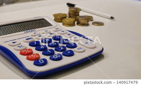 Calculator and Coins on a Desk for Financial Planning Calculator and Coins on a Desk for Financial Planning 140917479