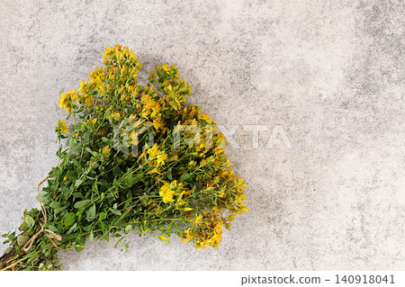 Hypericum flowers on a concrete table, herbal remedies, alternative folk medicine concept, green pharmacy advertisement, collection of useful herbs for folk medicine, source of vitamins Hypericum flowers on a concrete table, herbal remedies, alternative folk medicine concept, green pharmacy advertisement, collection of useful herbs for folk medicine, source of vitamins 140918041