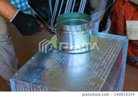 Plumbing builder works on HVAC vent metal device using tools during duct assemble Plumbing builder works on HVAC vent metal device using tools during duct assemble 140918154