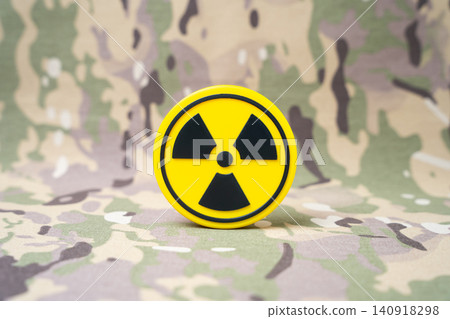A radiation symbol on a military background. Nuclear deterrent weapons, deployment of carriers and infrastructure in third countries of military blocs. A radiation symbol on a military background. Nuclear deterrent weapons, deployment of carriers and infrastructure in third countries of military blocs. 140918298