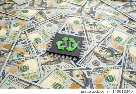 A microchip with a recycling symbol lies against a background of dollar bills. Recycling of electronic waste, recovery of precious metals for secondary use. A microchip with a recycling symbol lies against a background of dollar bills. Recycling of electronic waste, recovery of precious metals for secondary use. 140918340