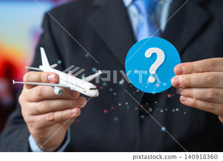 An airplane and a question mark in an official's hand. Frequently asked questions about air travel and booking tickets. Flight information. Forecasts in the aviation industry. 140918360