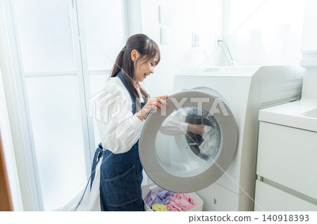 家庭主婦用滾筒洗衣機洗衣服 140918393