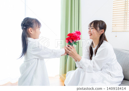 A little girl gives her mother a bouquet of carnations. A little girl gives her mother a bouquet of carnations. 140918414