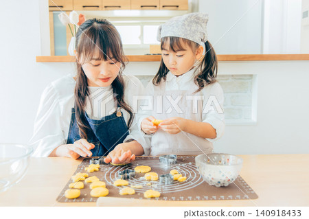 A girl and her mom making cookies A girl and her mom making cookies 140918433