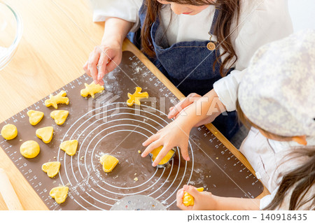 A girl and her mom making cookies A girl and her mom making cookies 140918435