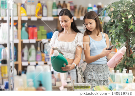 Woman with daughter scanning qr code for detergent Woman with daughter scanning qr code for detergent 140919788