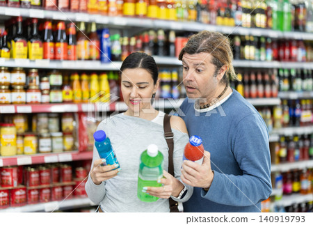 Couple in supermarket choose drink Couple in supermarket choose drink 140919793