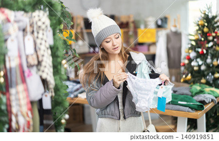 woman in a hat chooses a set of panties against the background of a Christmas tree woman in a hat chooses a set of panties against the background of a Christmas tree 140919851