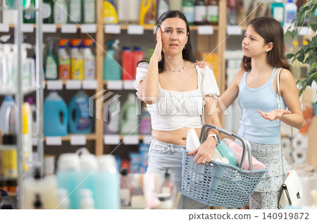 Upset and tired mother with shopping basket argues with her teen daughter 140919872