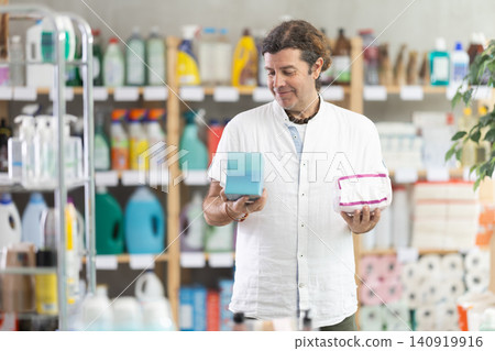 Adult man chooses feminine pads in store Adult man chooses feminine pads in store 140919916
