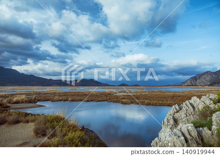 View of Dalyan River Delta and lagoon near Iztuzu Beach known as Turtle beach, Turkey. Wetlands, mountains and calm waterways create popular destination for summer travel, wildlife and nature tourism. 140919944