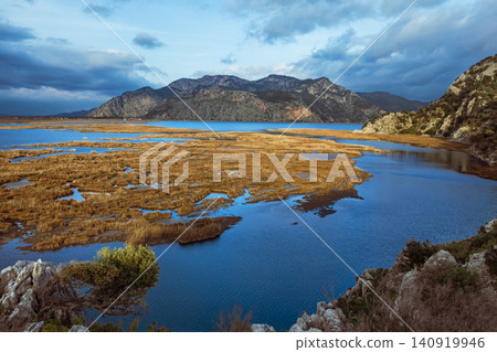 View of Dalyan River Delta and lagoon near Iztuzu Beach known as Turtle beach, Turkey. Wetlands, mountains and calm waterways create popular destination for summer travel, wildlife and nature tourism. View of Dalyan River Delta and lagoon near Iztuzu Beach known as Turtle beach, Turkey. Wetlands, mountains and calm waterways create popular destination for summer travel, wildlife and nature tourism. 140919946