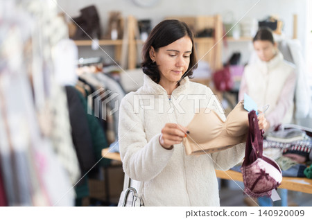 Adult woman chooses underwear in clothing store Adult woman chooses underwear in clothing store 140920009