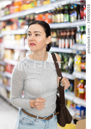 Adult woman choosing groceries in grocery store Adult woman choosing groceries in grocery store 140920038