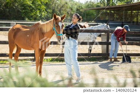 Young woman with horse in horse paddock Young woman with horse in horse paddock 140920124