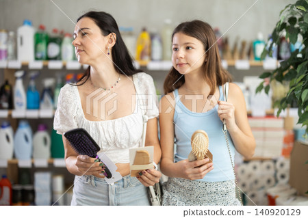 Mom and daughter choosing comb in store in summer Mom and daughter choosing comb in store in summer 140920129