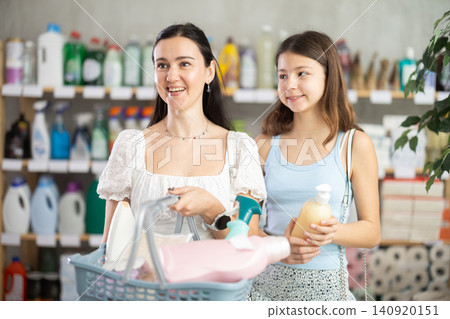 Woman with daughter choosing household chemicals in store 140920151