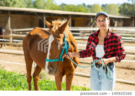 Young woman with horse in horse pen Young woman with horse in horse pen 140920160