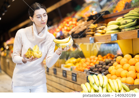 Woman choosing bananas in the store 140920199