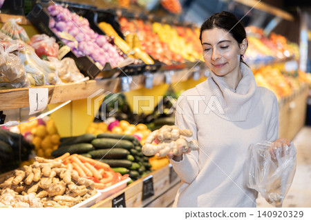 Woman choosing ginger at the grocery store Woman choosing ginger at the grocery store 140920329