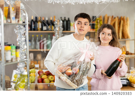 Couple man and woman choosing wine and food gift box Couple man and woman choosing wine and food gift box 140920383