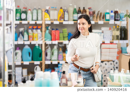 woman chooses household chemicals in a supermarket woman chooses household chemicals in a supermarket 140920416