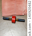 A top view of a modern abdominal wheel exercise roller with custom titanium rainbow handles and red wheel. Perfect for home workout, fitness equipment, and healthy lifestyle concepts. 140920482
