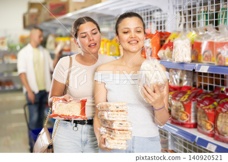 Woman invites her friend to buy traditional Chinese noodles at grocery store. Woman invites her friend to buy traditional Chinese noodles at grocery store. 140920521