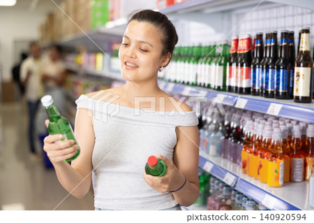 Young woman choosing soda in store Young woman choosing soda in store 140920594
