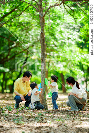 A family of four goes insect hunting in the forest during summer vacation. A family of four goes insect hunting in the forest during summer vacation. 140920796