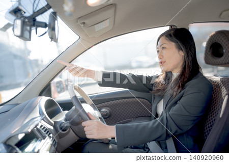 一位女商人坐在車上指路。 一位女商人坐在車上指路。 140920960